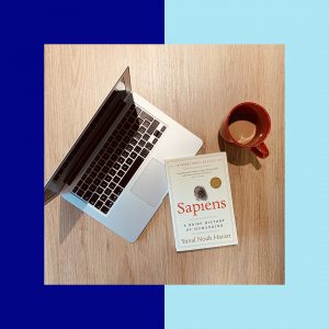 Le livre Sapiens, un ordinateur et un café