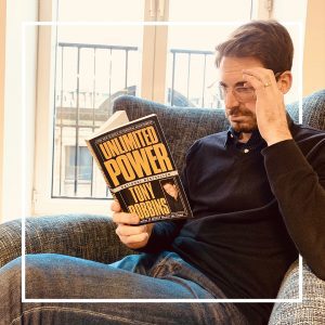Une homme lit Unlimited Power de Tony Robbins