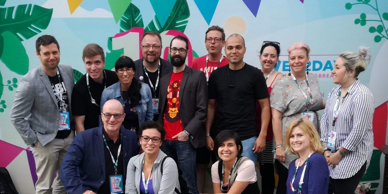 Photographie de plusieurs personnes devant la pancarte d'accueil du Web2day